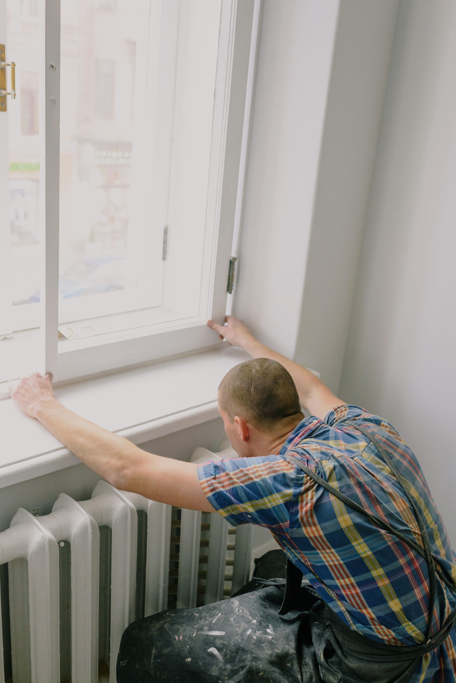 Handwerker justiert einen Fensterflügel bei einer Kleinreparatur