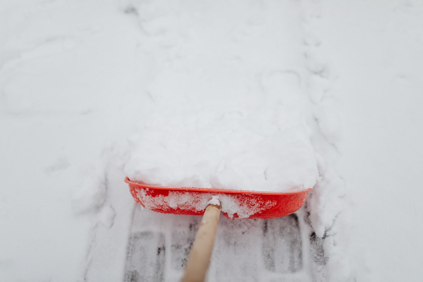 Schneeräumung mit dem Schneeschieber auf einem Gehweg